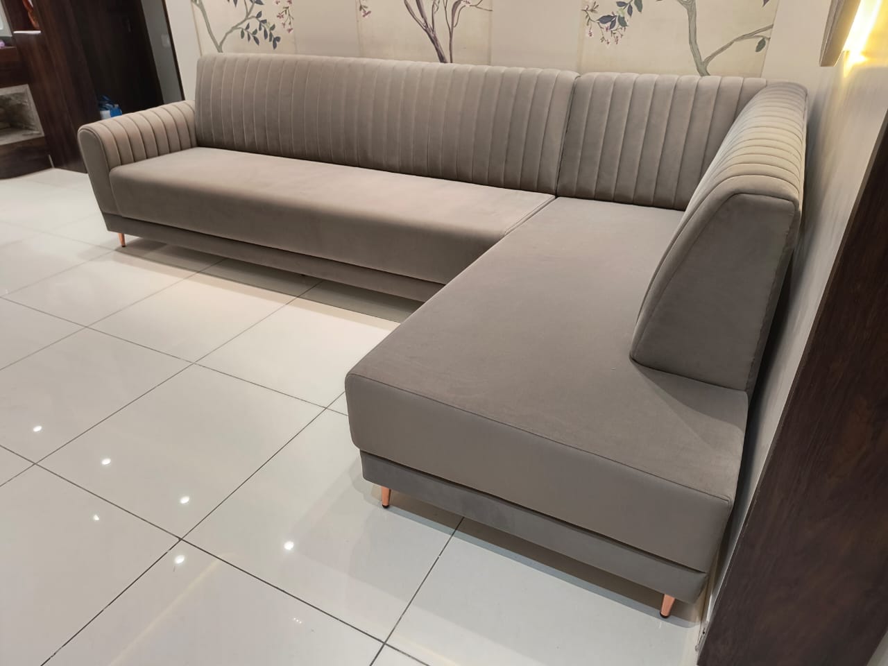 Grey velvet L-shaped corner sofa with channel-stitched back