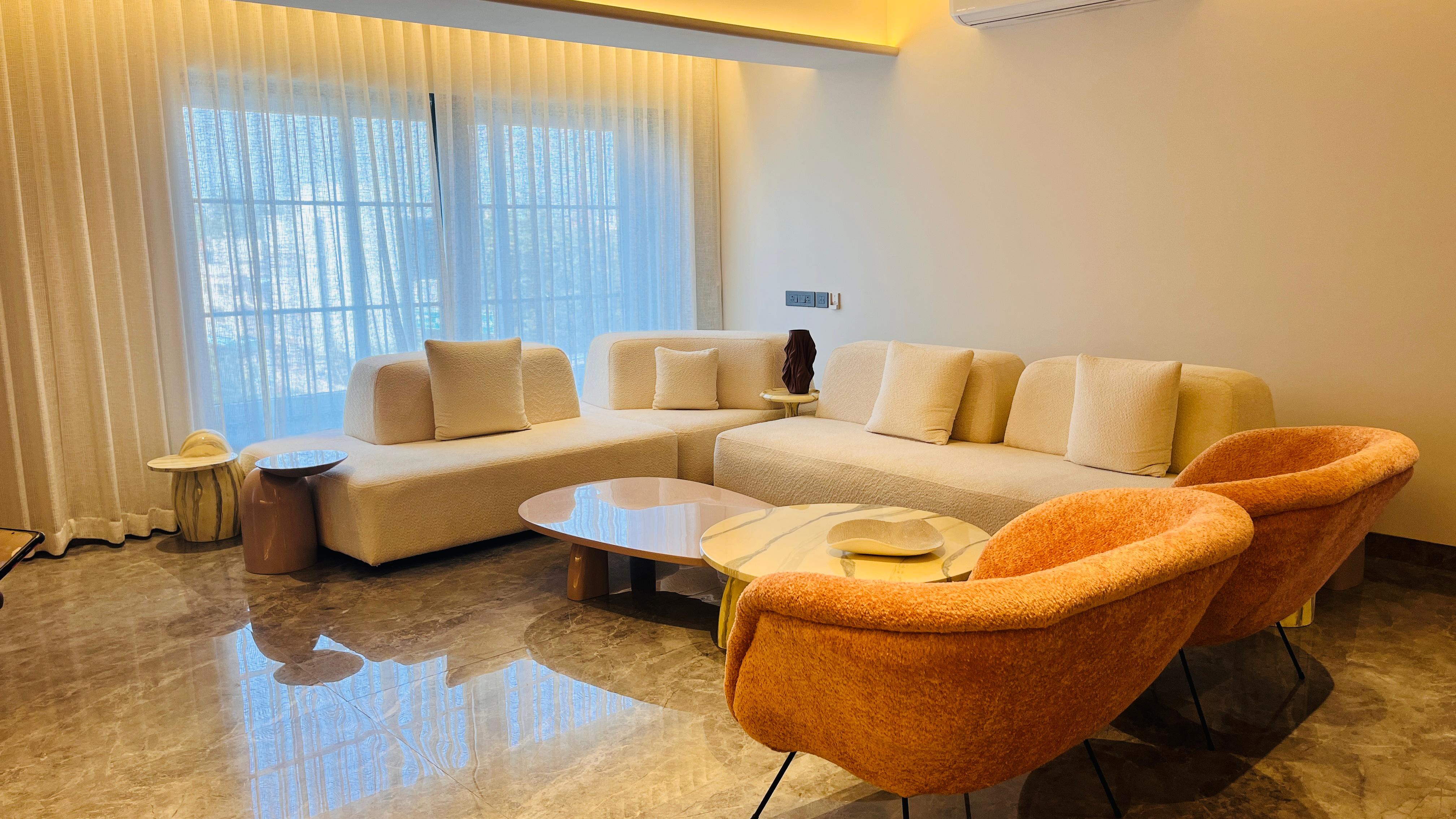 Cream boucle modular sofa with burnt-orange accent chairs